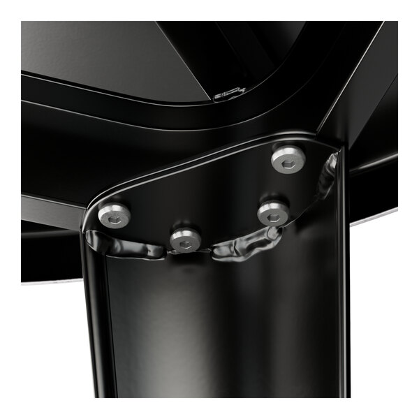 A close-up of a Lancaster Table & Seating round black metal table with metal legs.