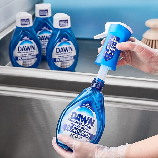 A hand pouring blue Dawn dish soap into a white bottle.