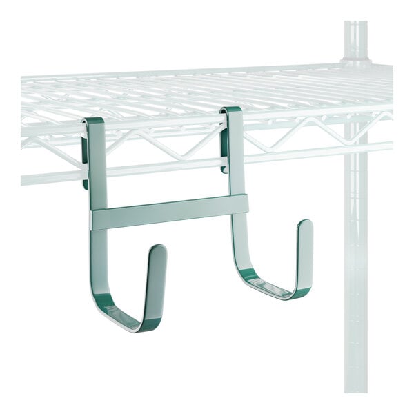 A white wire shelf with large green double snap-on J-hooks attached.