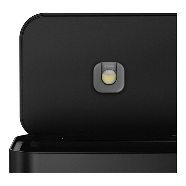 A black rectangular simplehuman trash can with a round hole in the middle.
