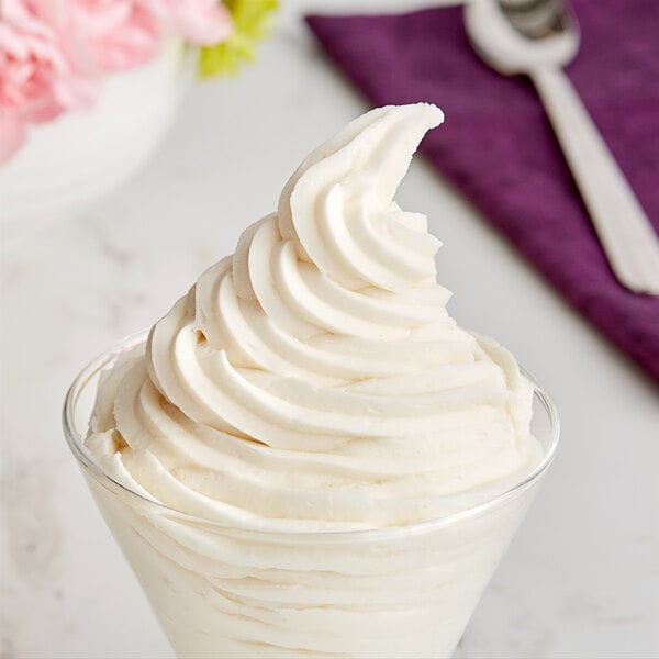 A glass with white swirly Galliker's Vanilla soft serve ice cream in it.