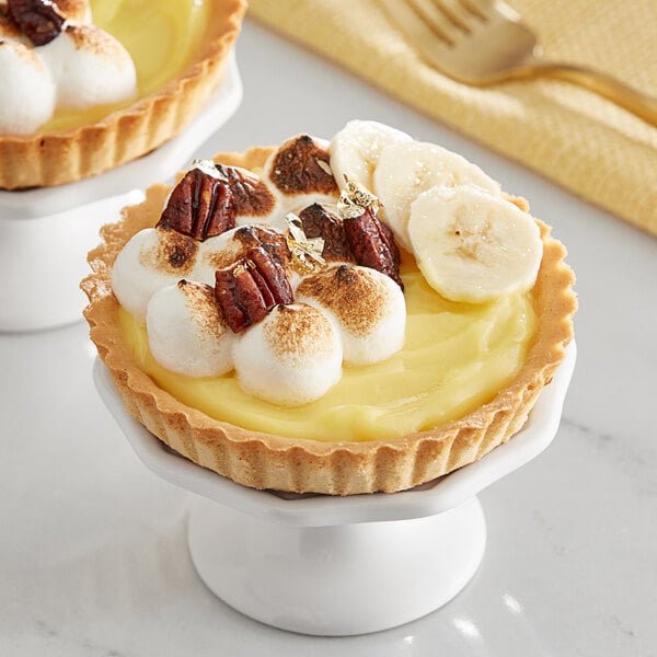 A pie with banana and marshmallows on top with a fork next to it.