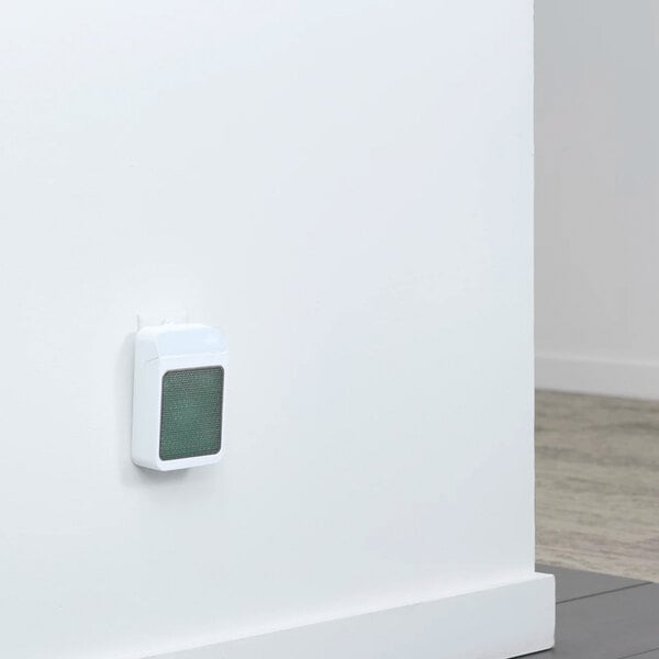 A wall-mounted air freshener refill unit with a white casing and a green front panel.