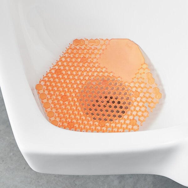 A urinal with a Fresh Products Wave 3D mango scented screen.