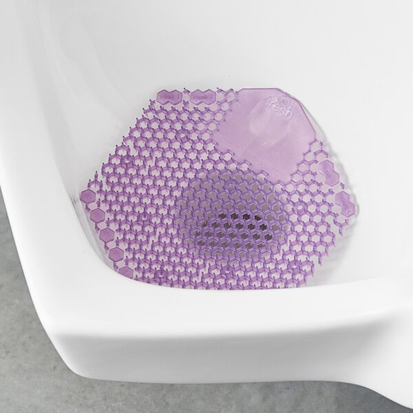 A white urinal mat with a purple hexagon in the center.