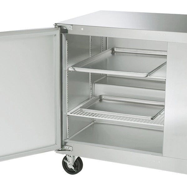 A stainless steel Traulsen undercounter freezer with two left hinged doors open.