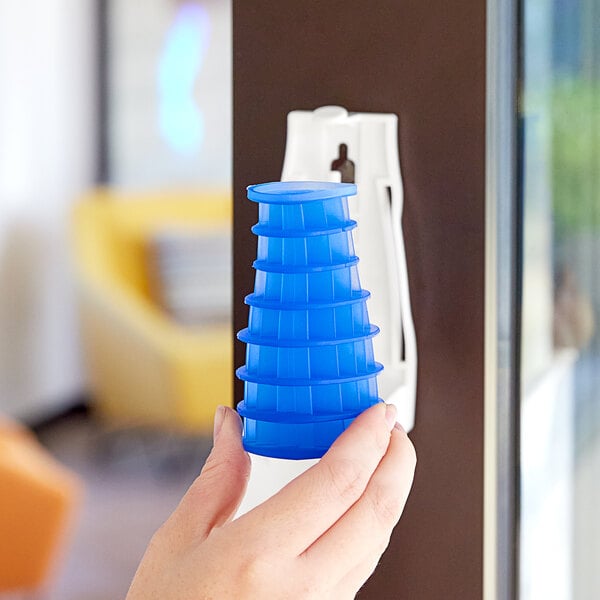 A hand holding a blue and white cone-shaped Fresh Products air freshener refill.