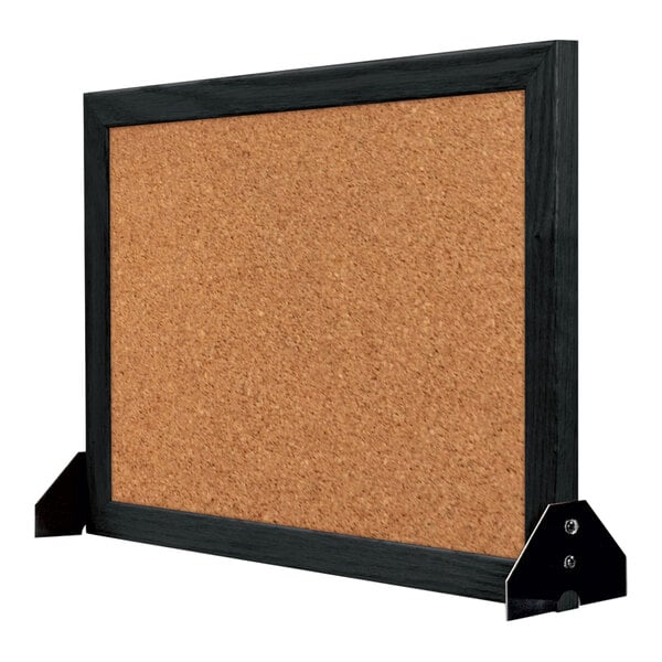 A cork board with a black wood frame.