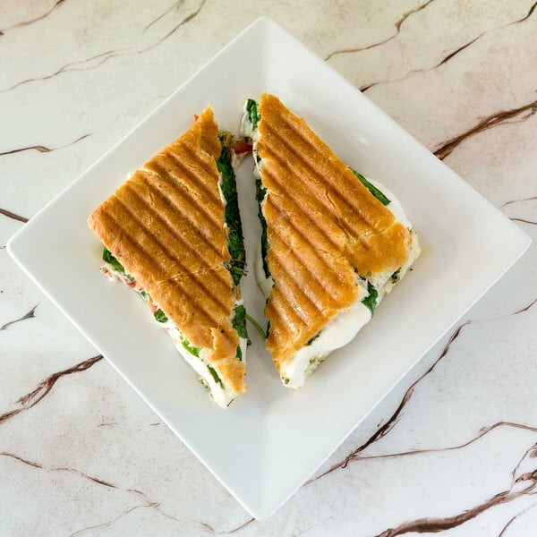 A sandwich on a 10 Strawberry Street Whittier white square porcelain plate.