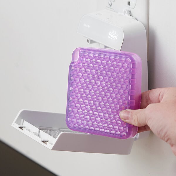 A person's hand using a purple plastic Ourfreshe air freshener refill container with holes.