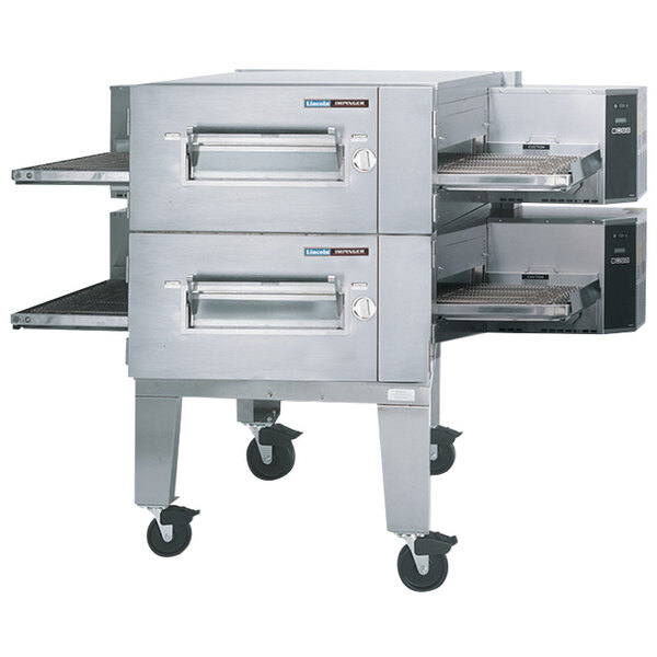 A Lincoln Impinger conveyor oven with wheels and the lid open.