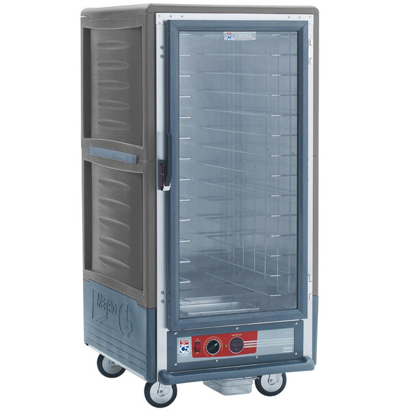 A large grey Metro C5 holding cabinet with a glass door and wheels.