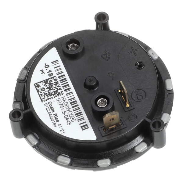 A round black device with a white label.