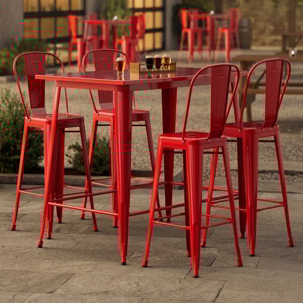 A Lancaster Table & Seating ruby red bar table with 4 chairs.