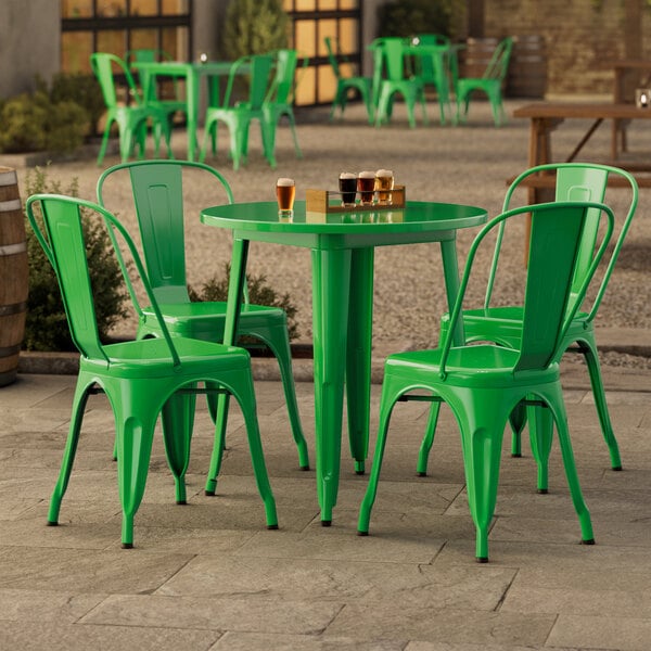 A Lancaster Table & Seating jade green table with chairs outside on a patio.