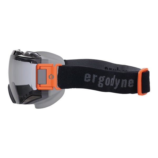 An Ergodyne Skullerz MODI safety goggle with a black and orange strap.