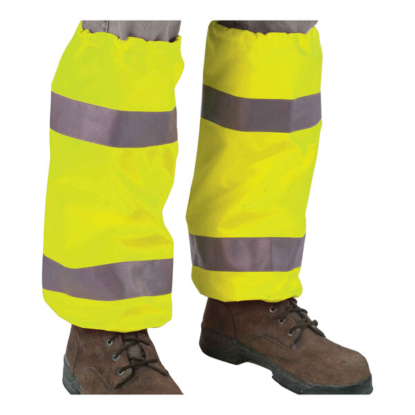 The lower legs of a person wearing Ergodyne hi-vis yellow leg gaiters with reflective tape.