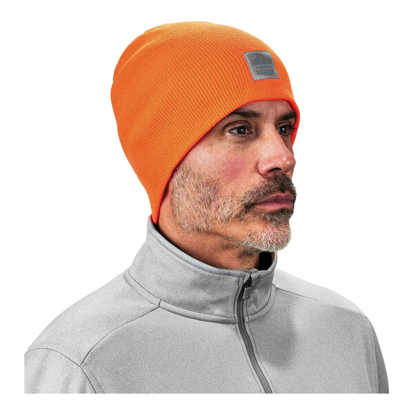 A man wearing an orange Ergodyne rib knit winter hat.