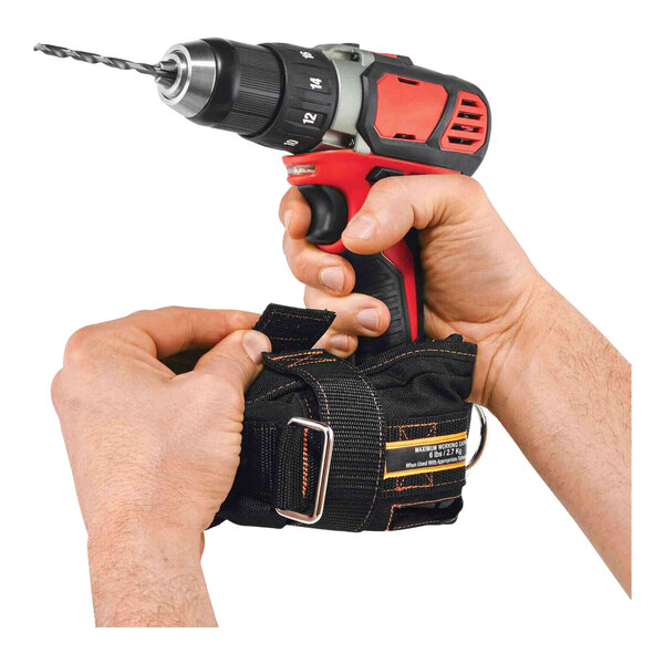 A person using an Ergodyne Squids Small Power Tool Trap to tether a drill.