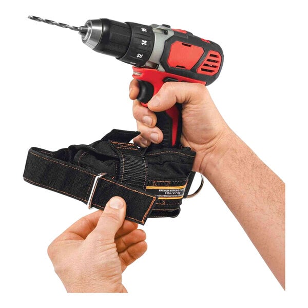 A hand holding a black belt attached to a drill.