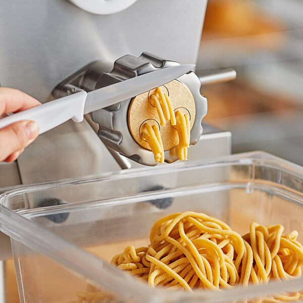 A person using an Estella Bigoli pasta die to cut noodles.