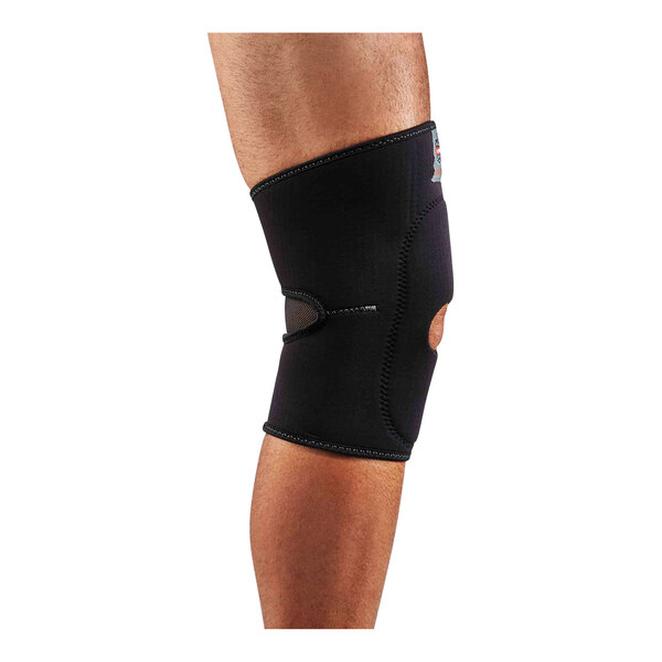 A person wearing an Ergodyne ProFlex black knee compression sleeve with open patella and anterior pad.