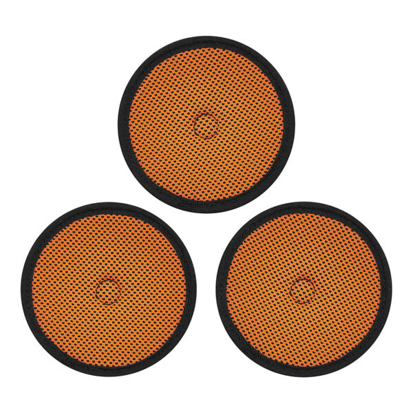 A close-up of three black and orange circle pads.