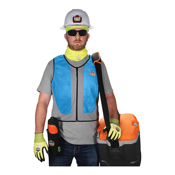 A man wearing an Ergodyne Chill-Its cooling vest and a hard hat holding a tool box.