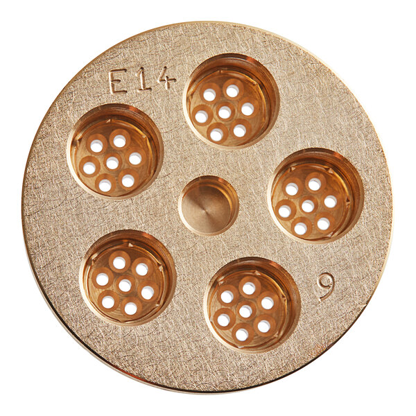A circular gold metal surface with a circular center with small holes in it.