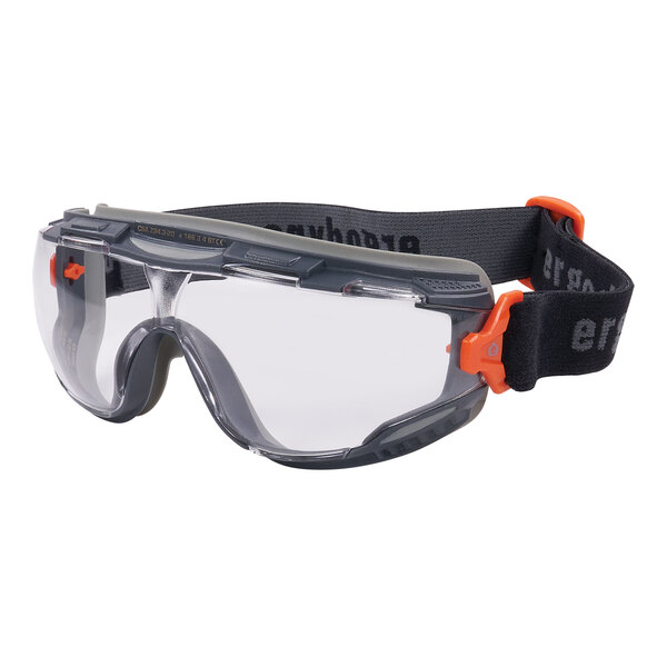 A pair of Ergodyne Skullerz safety goggles with a clear lens, gray frame, and orange strap.