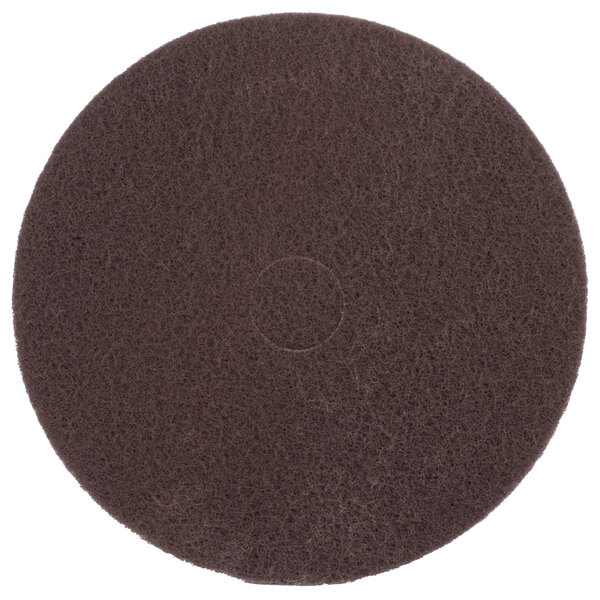 A brown circular Scrubble floor pad with a circle in the middle.