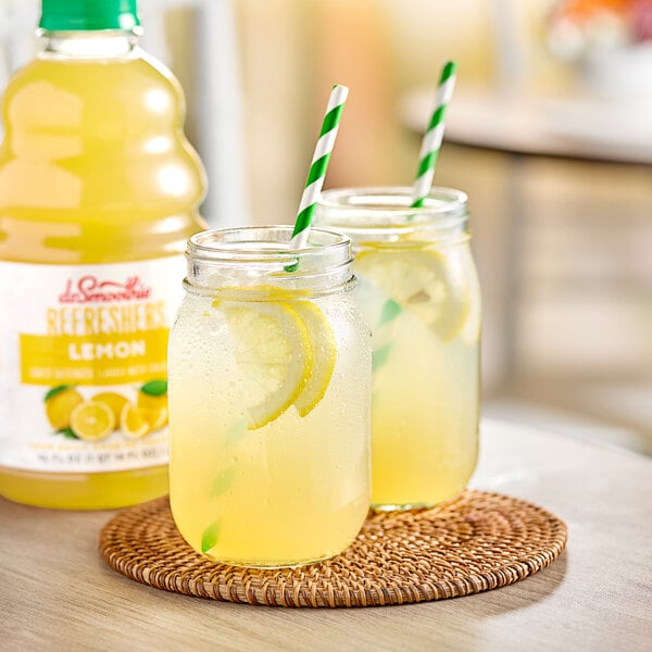 A bottle of Dr. Smoothie Lemon Refresher with two glasses of lemonade and straws.