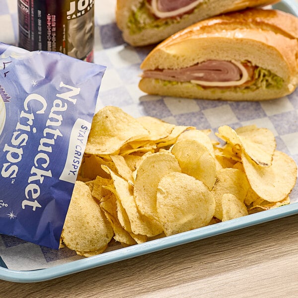 A plate of food with a sandwich and Nantucket Crisps Madaket Sweet Onion Potato Chips on it.
