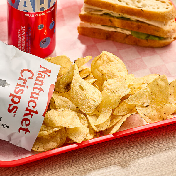 A tray of Nantucket Crisps Sconset Sea Salt Potato Chips next to a sandwich.
