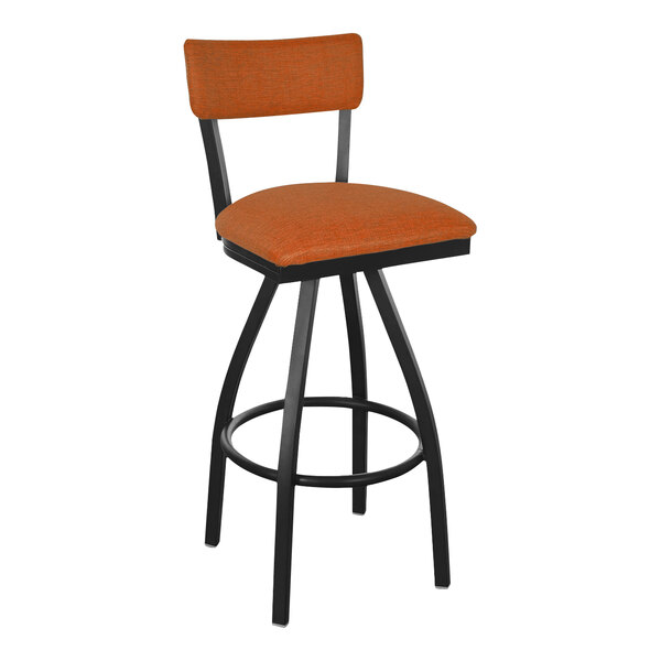 A black BFM Seating swivel barstool with an orange cushion and back.