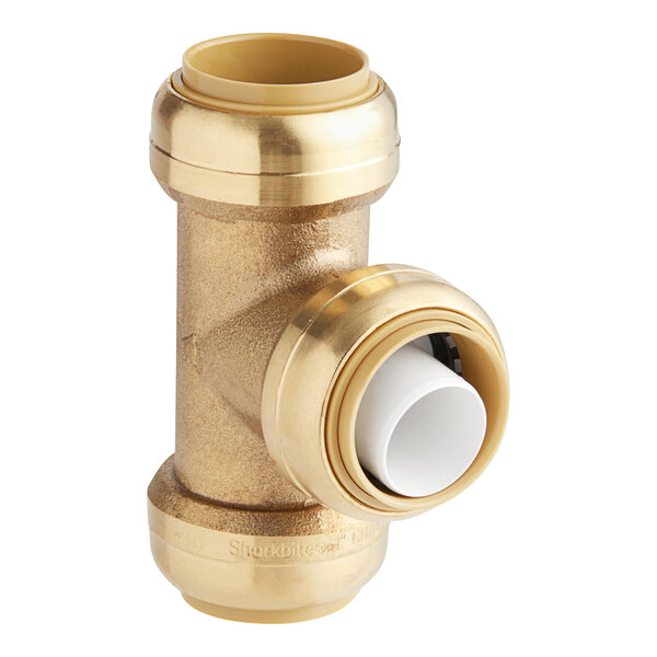 A brass SharkBite tee fitting with white plastic inside.