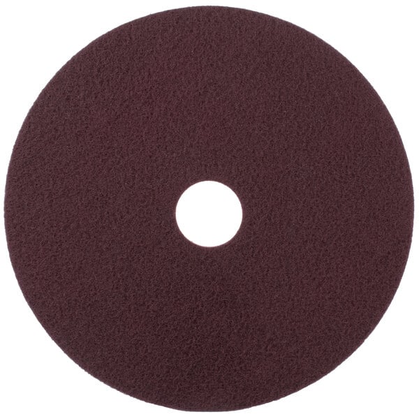 A brown circular Scrubble conditioning pad with a hole in the middle.