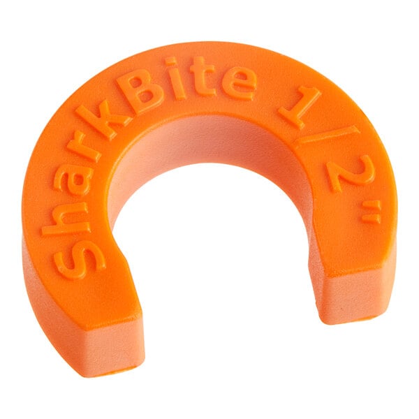 An orange plastic SharkBite disconnect clip.