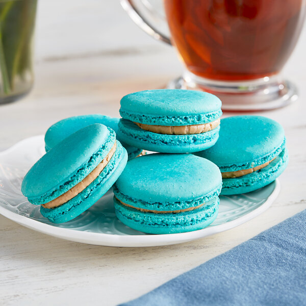 A plate of turquoise Coco Bakery salted caramel macarons.