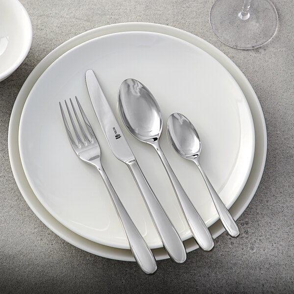 A white plate with a Sola stainless steel dinner knife on it.