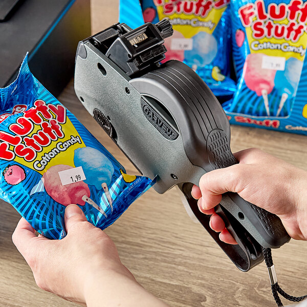 A hand using a Garvey G-Series label gun to label a bag of candy.