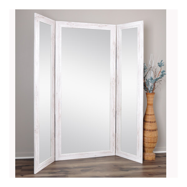 A BrandtWorks white trifold dressing mirror.