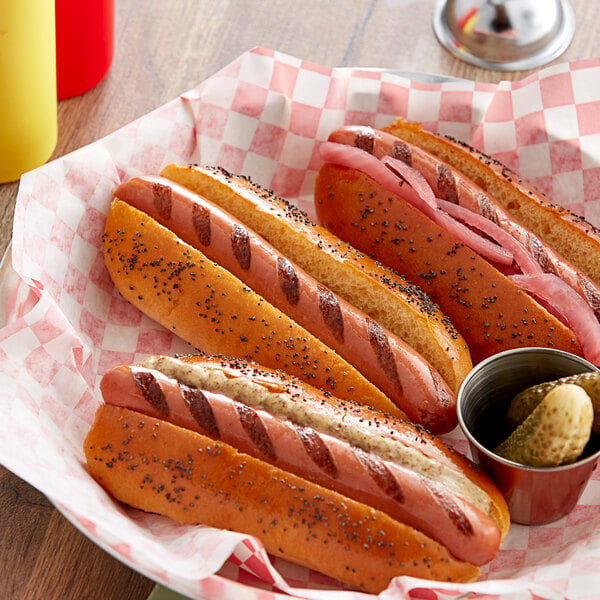 A group of Sabrett beef hot dogs on a red and white checkered paper.