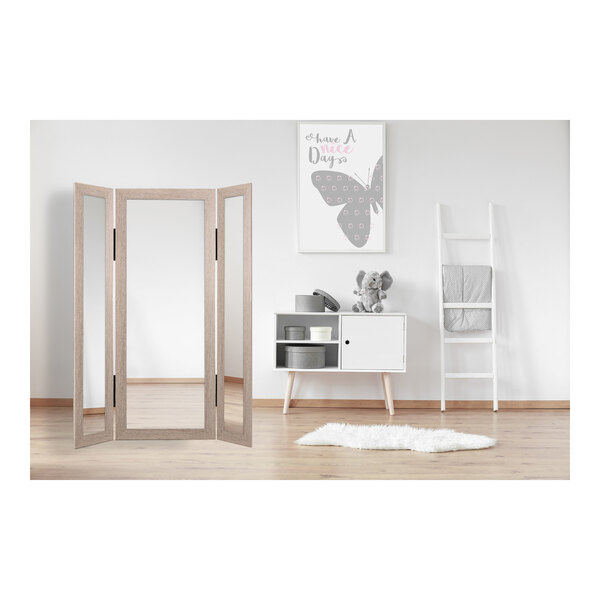 A BrandtWorks trifold dressing mirror with a light grain wooden frame.