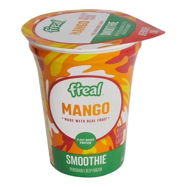 A plastic container of f'real mango smoothie on a table.