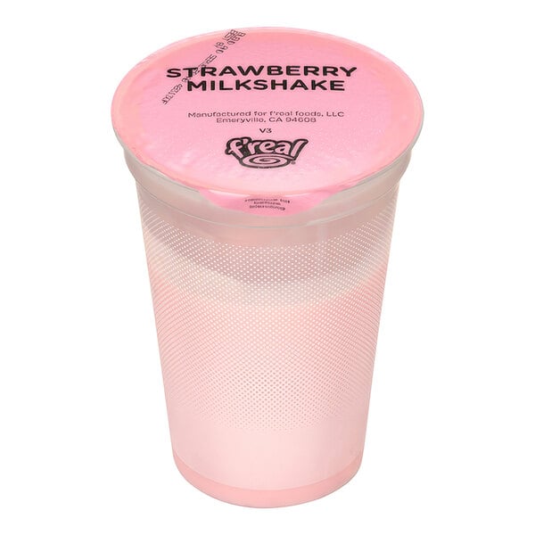 A pink plastic container with a f'real strawberry milkshake and a pink lid.