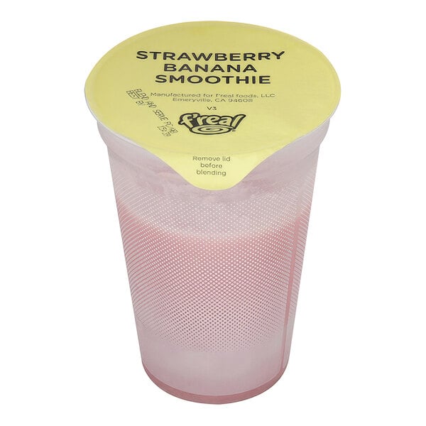 A plastic container of f'real Strawberry Banana Smoothie with a straw in it.