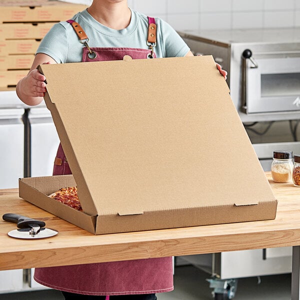 A woman holding a Choice kraft cardboard pizza box.