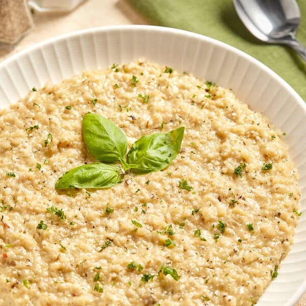 A bowl of Simplot Simple Goodness Riced Cauliflower with a spoon next to it.