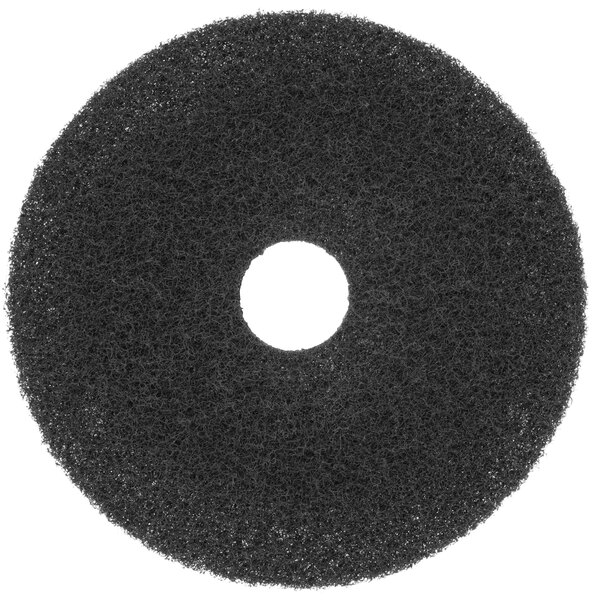 A black circular Scrubble super stripping floor pad with a hole in the center.